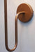 Elegant wall lamp design with a black shade and a unique copper metal arm, perfect for modern interiors
